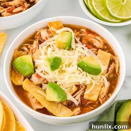 Fiesta Chicken Tortilla Soup 9 A perfectly garnished bowl of chicken tortilla soup with avocado, cheese, and a lime wedge.