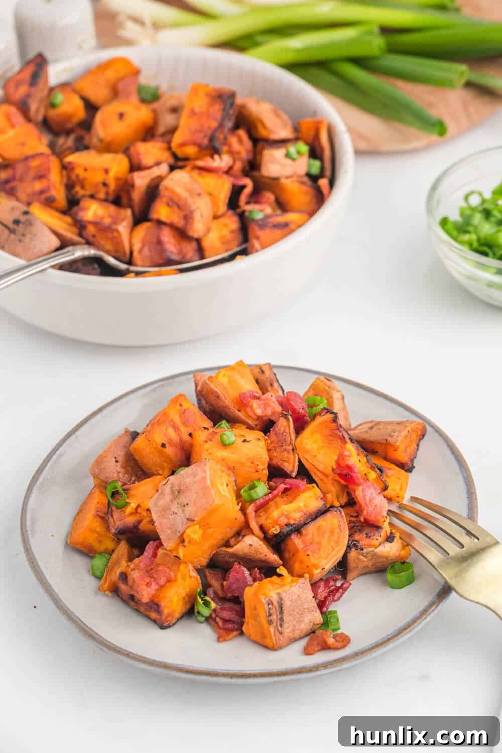 Sweet potato home fries on a plate with a fork, ready to eat.