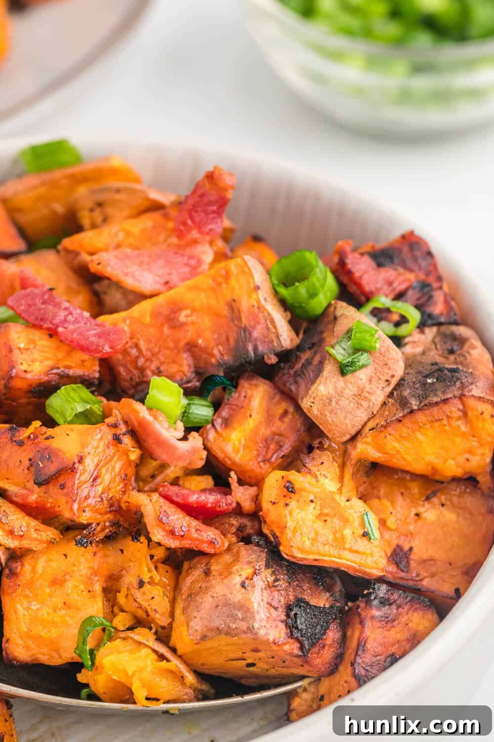 Sweet potato home fries being stirred in a pan.