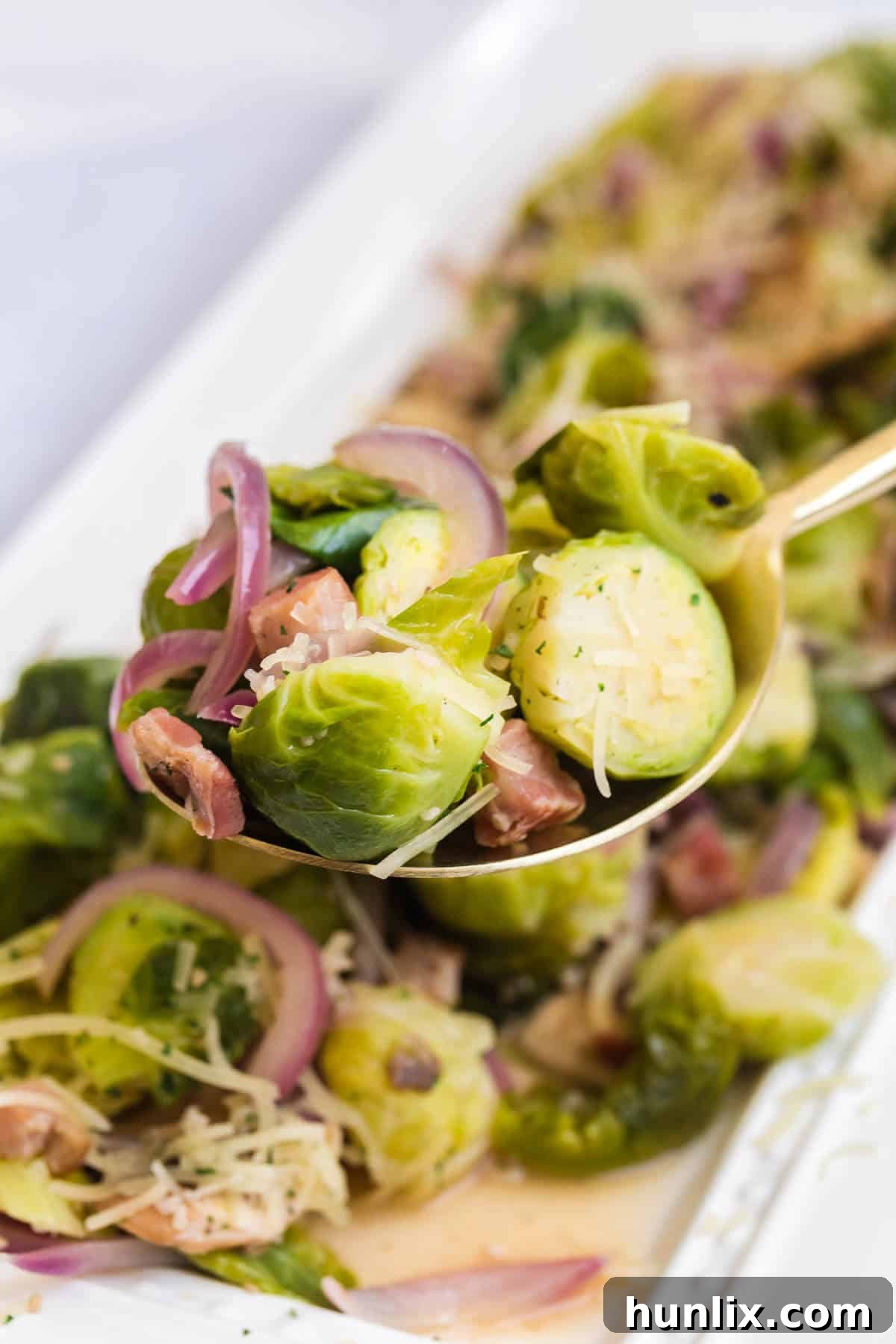 A generous portion of Brussels sprouts with lemon and pancetta on a rustic serving spoon, garnished with fresh herbs and ready to be enjoyed.