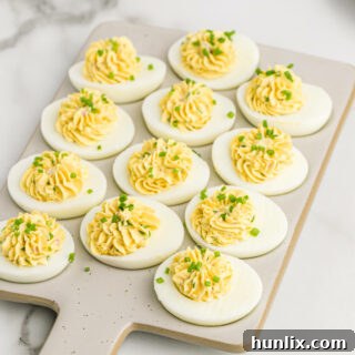Devilish eggs on a grey cutting board.