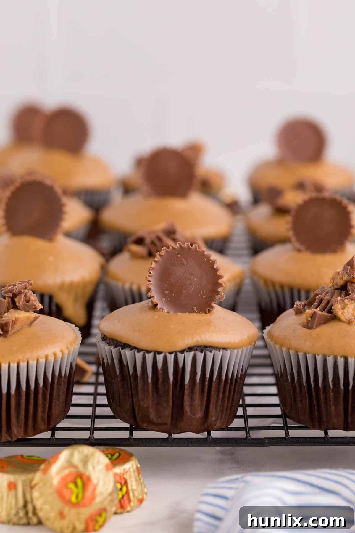 Ultimate Reese's Peanut Butter Cupcakes 3 Reese's cupcakes on a wire rack.