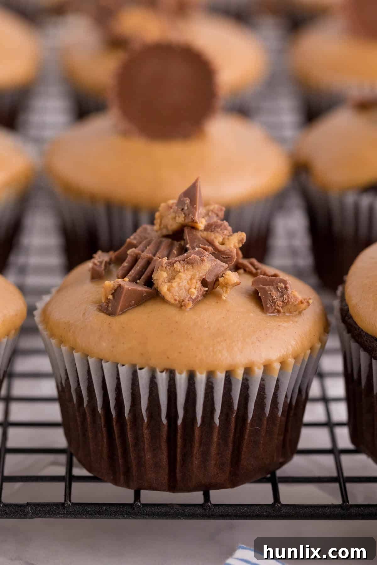 Ultimate Reese's Peanut Butter Cupcakes 4 Reese's cupcakes on a wire rack.