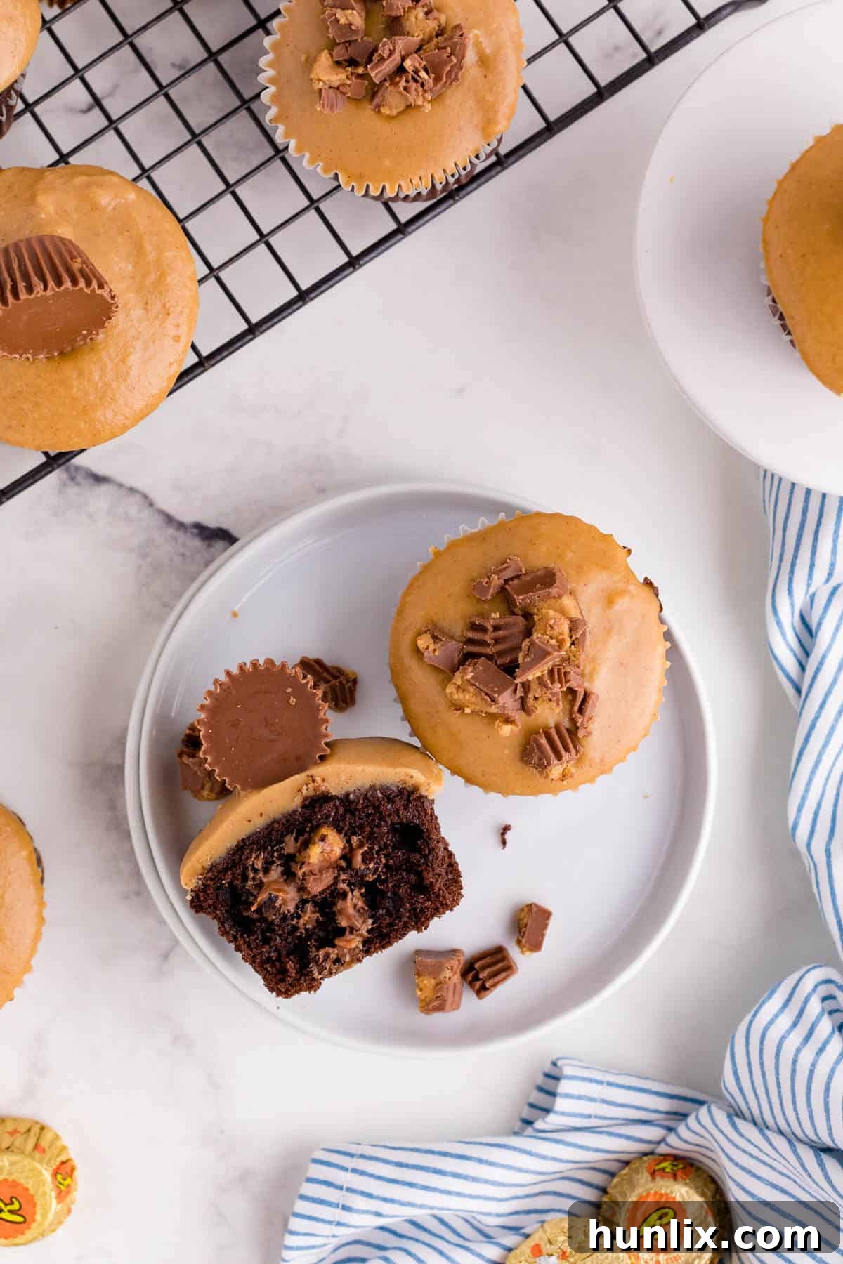 Ultimate Reese's Peanut Butter Cupcakes 6 A Reese's Cupcake cut in half on a plate.