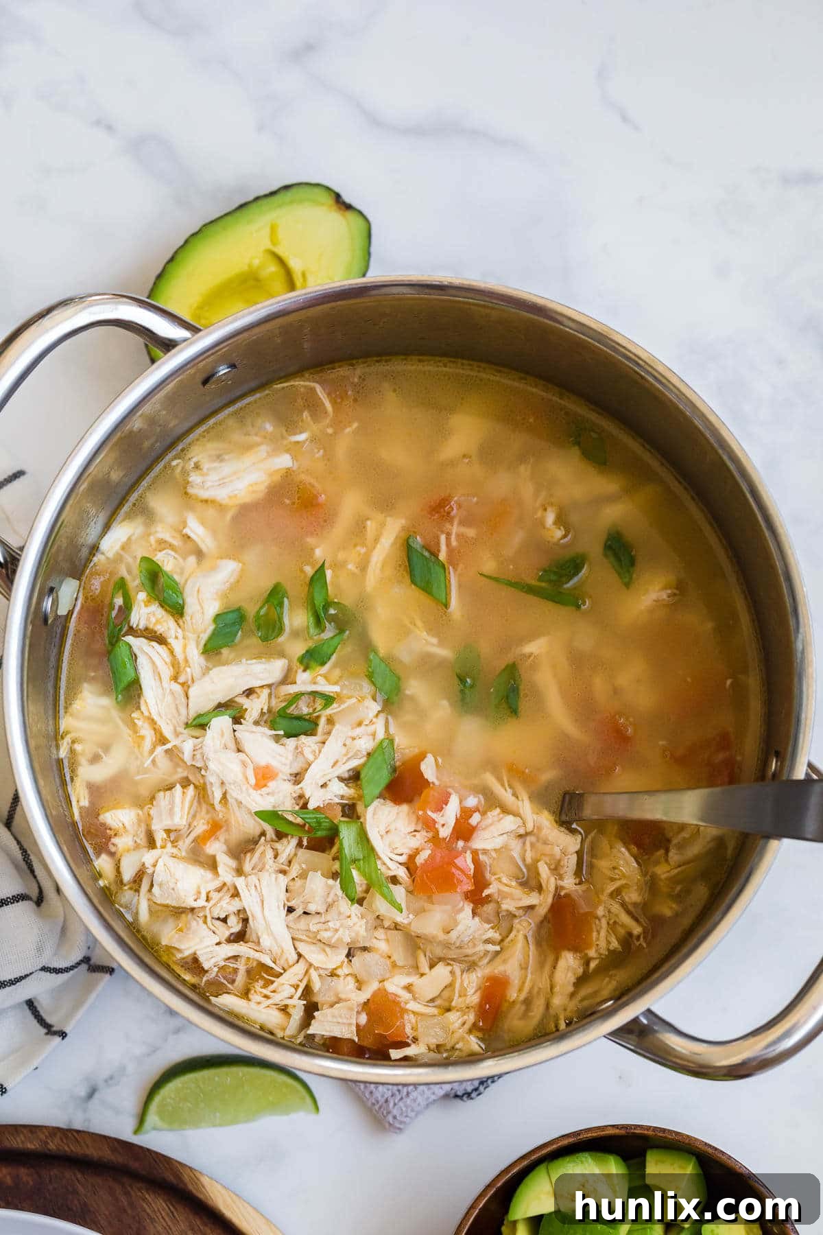 Chicken and Lime Soup in a large pot with a ladle, ready to be served.