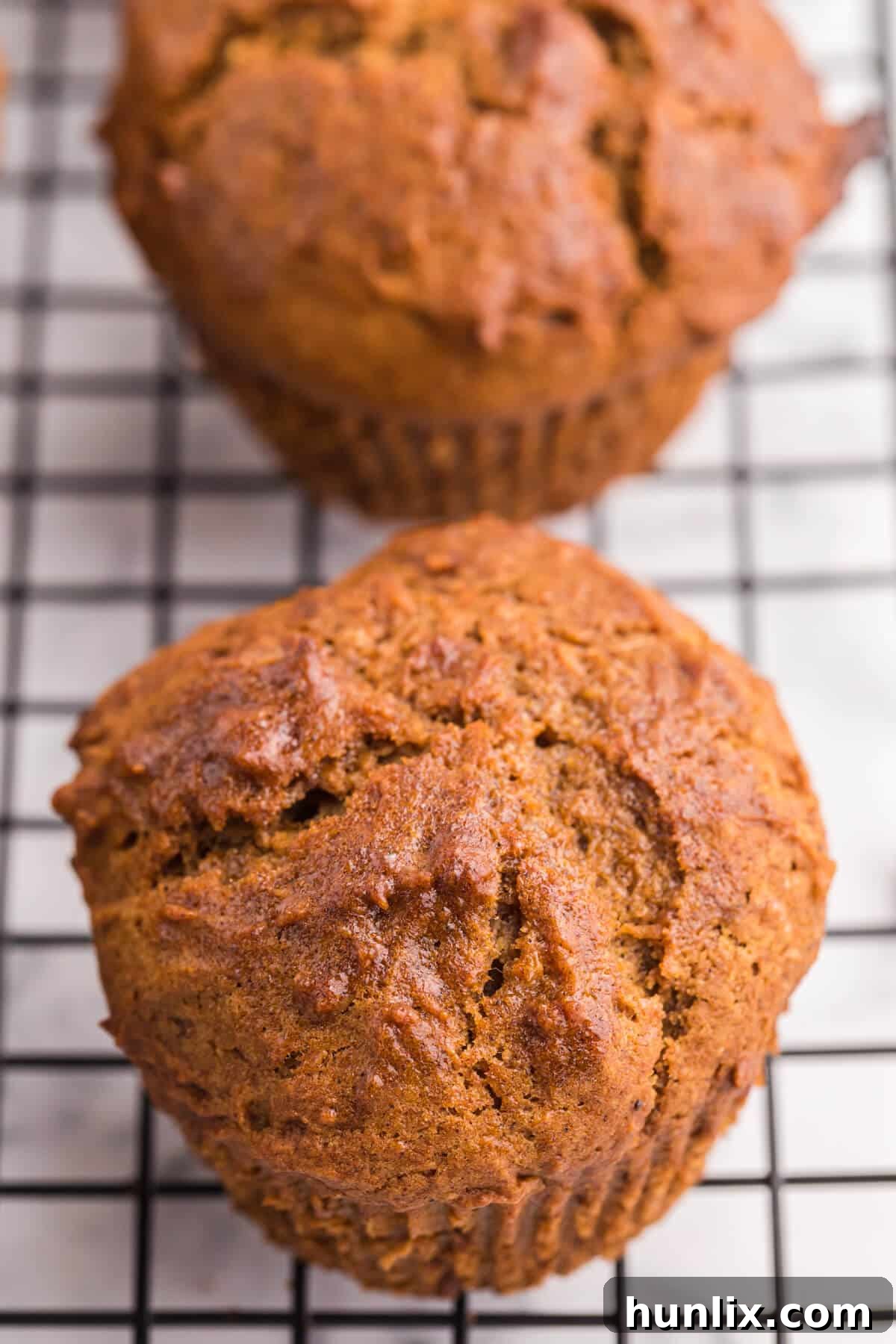 A close-up shot of several sweet potato muffins cooling on a wire rack, showcasing their golden tops and inviting texture.