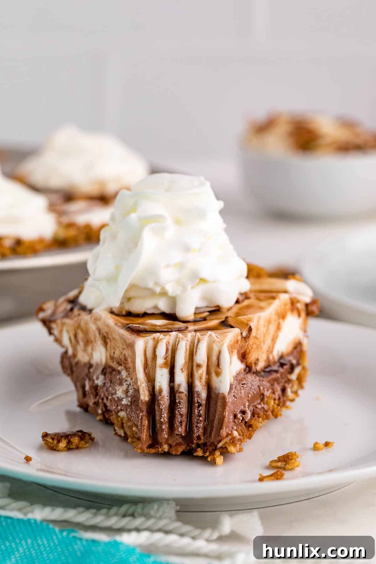 A slice of ice cream pie on a plate, with a bite taken from the end, highlighting its delicious layers and appealing texture.