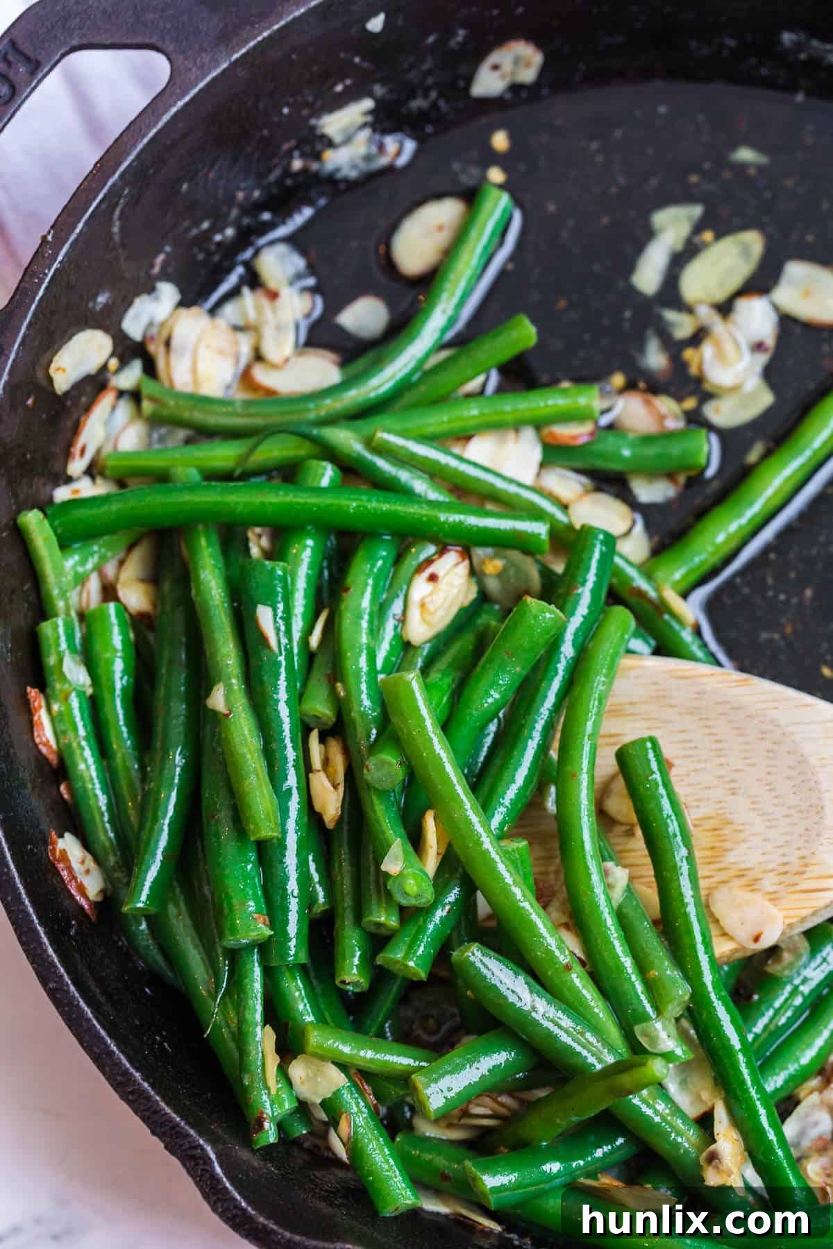 Buttery Chili Green Beans with Toasted Almonds 2 Vibrantly green chili buttered green beans and golden-brown almonds in a rustic skillet, ready to serve.