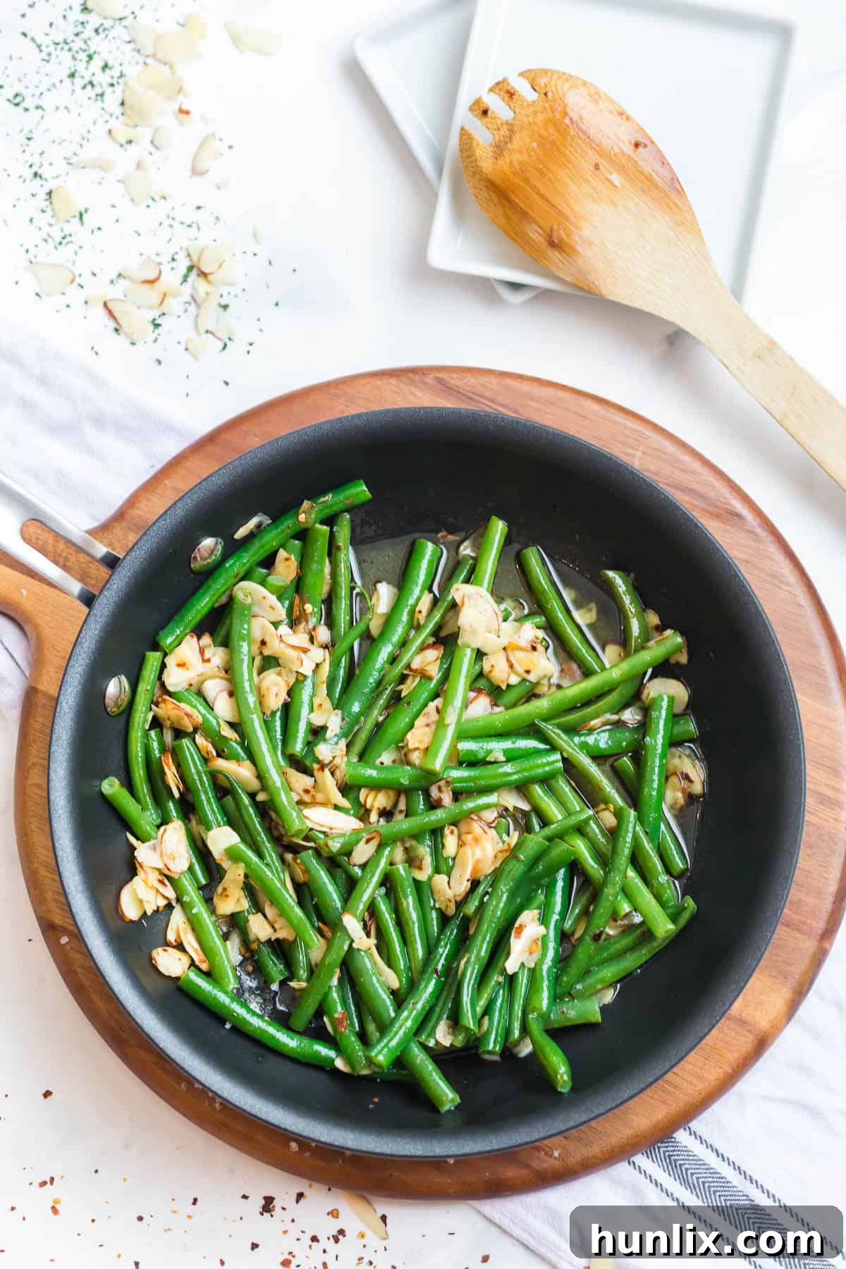 Buttery Chili Green Beans with Toasted Almonds 3 Close-up of chili buttered green beans simmering in a saucepan, highlighting their vibrant color.