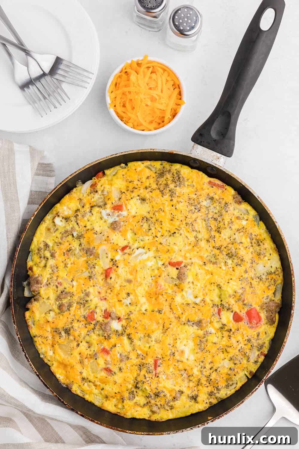 A delicious slice of Sausage & Red Pepper Frittata, showcasing perfectly cooked eggs, savory Italian sausage, and vibrant red peppers. A hearty and flavorful low-carb meal.