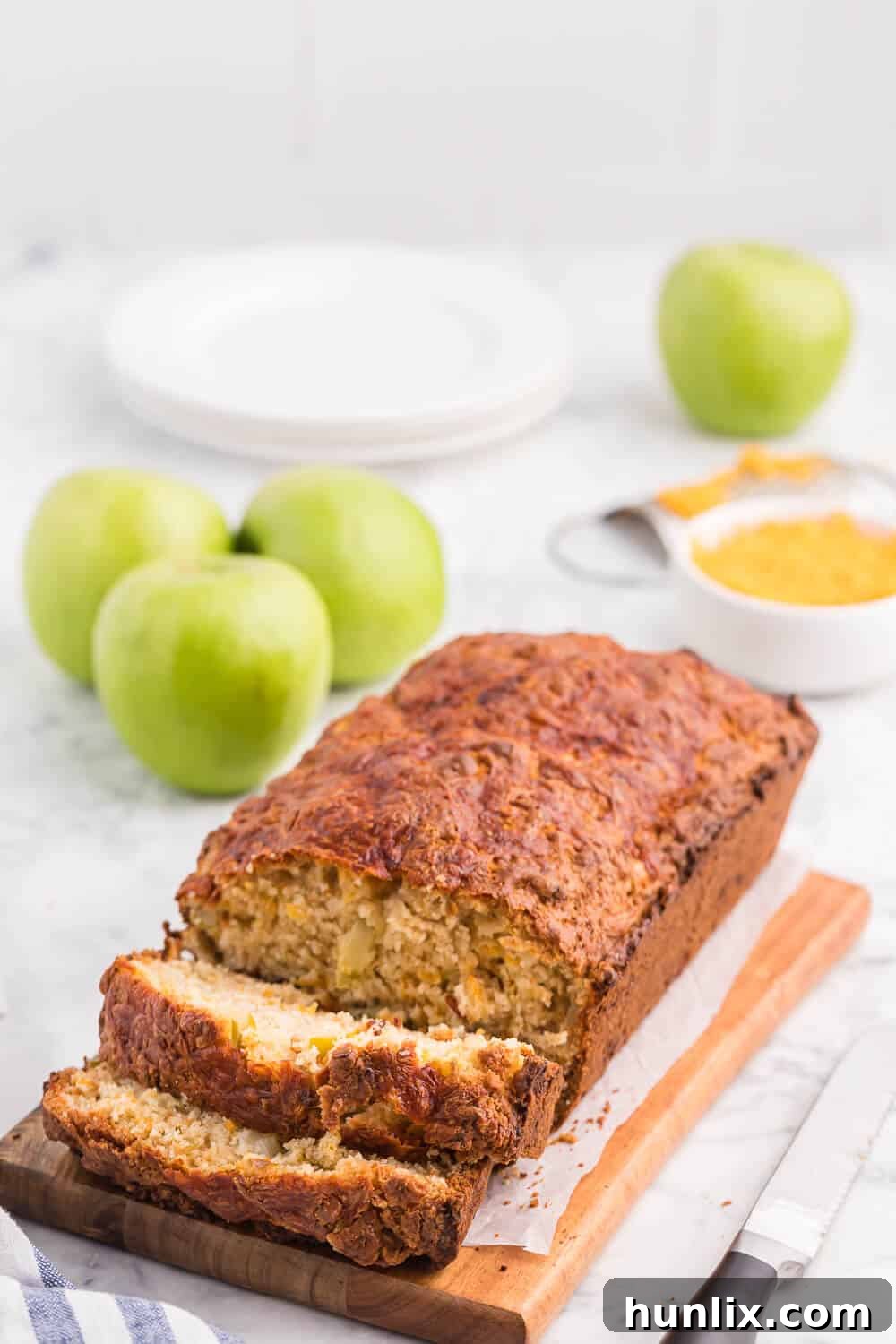 Tangy Cheddar and Sweet Apple Quick Bread 5 A large loaf of Apple Cheddar Quick Bread cooling on a wire rack after being freshly baked, with a golden-brown crust.