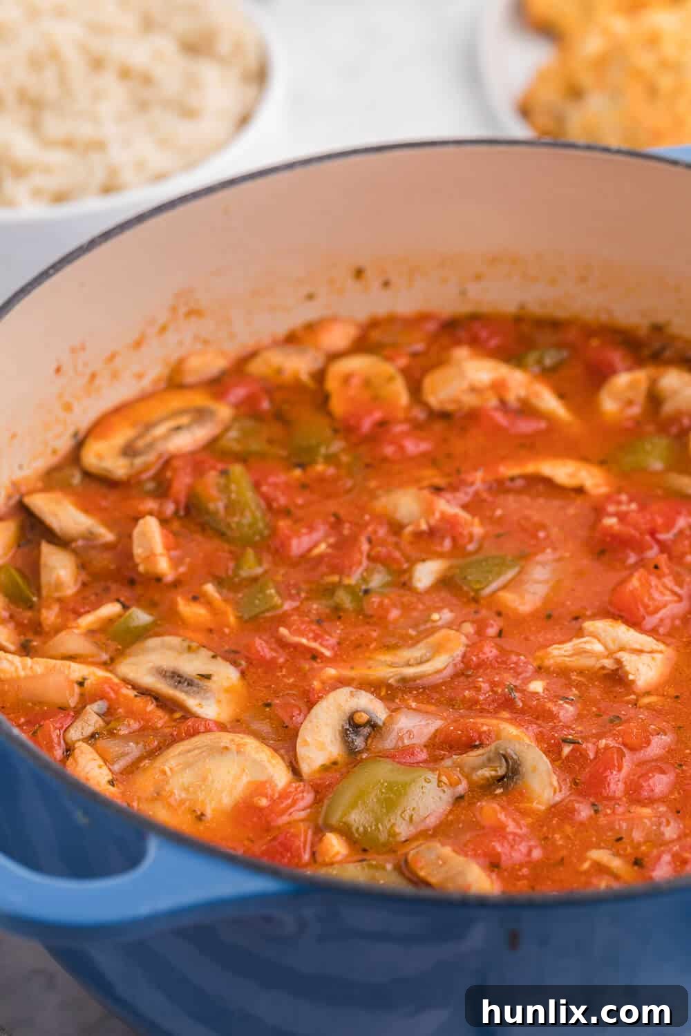 Fresh ingredients laid out for One-Pot Chicken Cacciatore, including chicken, vegetables, and seasoning.