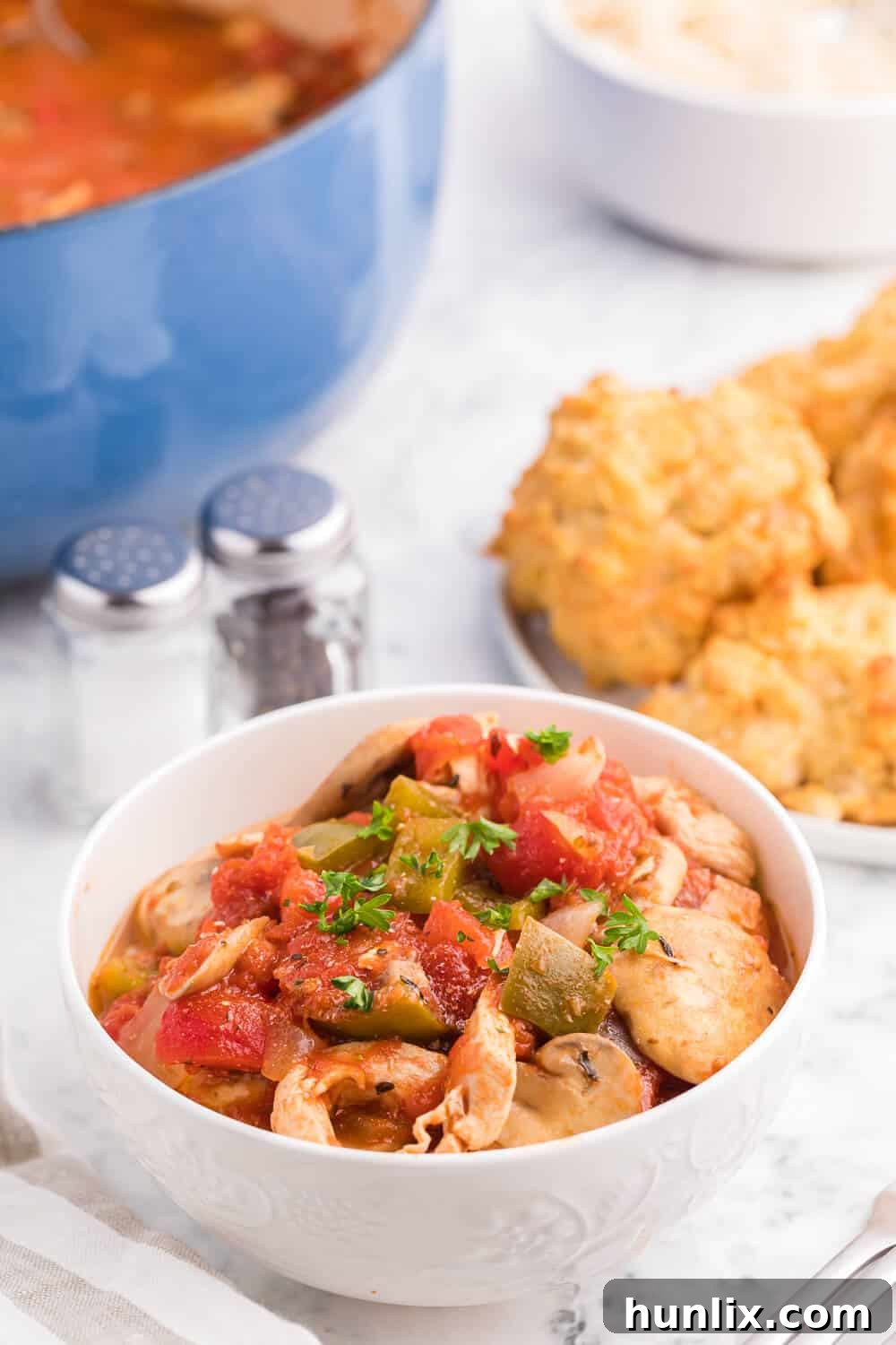 A Dutch oven filled with simmering One-Pot Chicken Cacciatore, ready to be served.