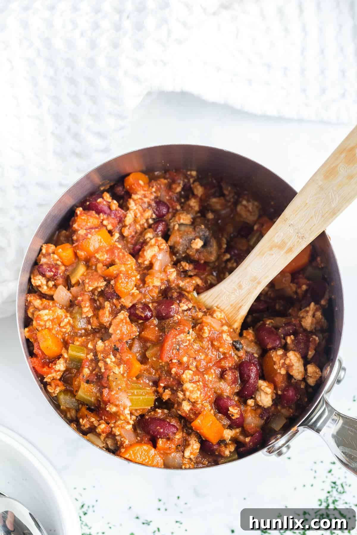 Chicken chili in a pot with a wooden spoon, ready to be served.