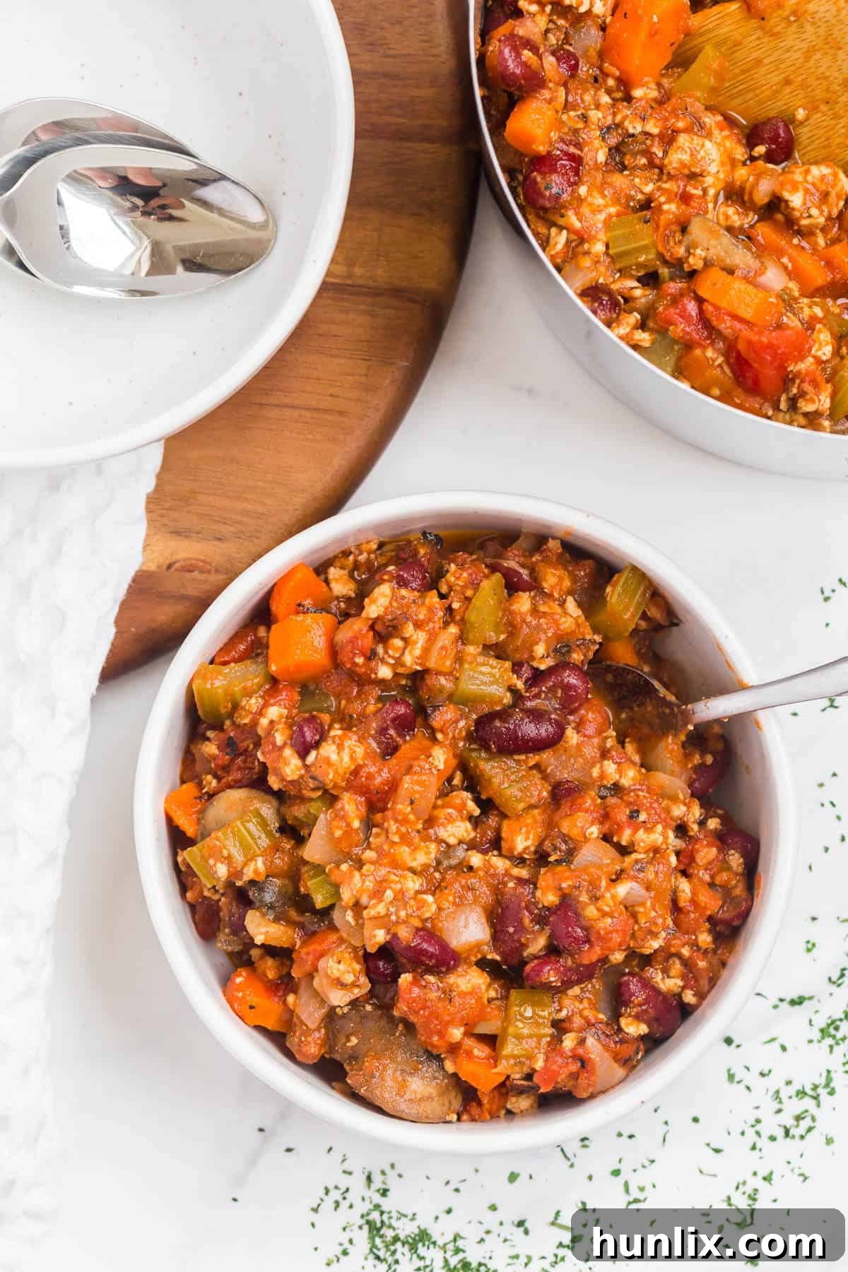 A bowl of hot chicken chili garnished with sour cream and cilantro.