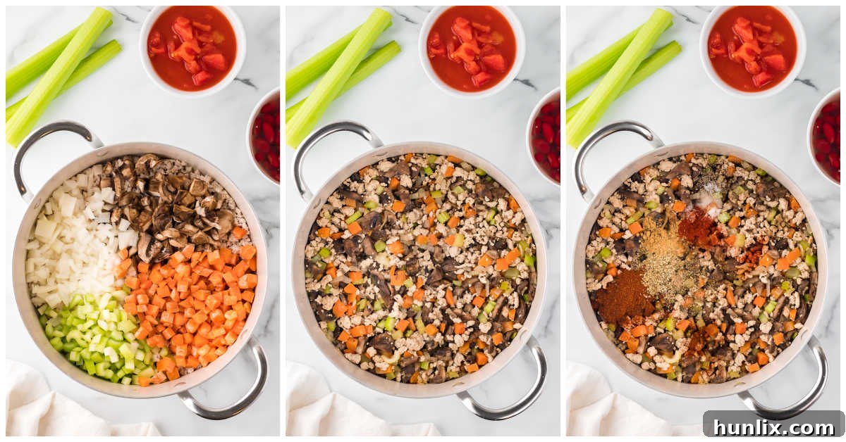 A close-up view of vegetables and ground chicken in a pot, with spices freshly added and being stirred.