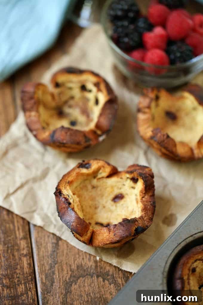 Golden brown cinnamon swirl bread cups filled with creamy Greek yogurt and fresh mixed berries, ready to eat.