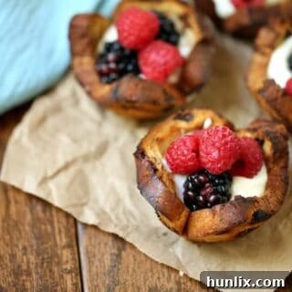 Mixed Berry Breakfast Cups - With a swirl of cinnamon and sweet raisins, these adorable little breakfast cups are begging to be filled as you wish! Try them filled with yogurt and mixed berries – yum!