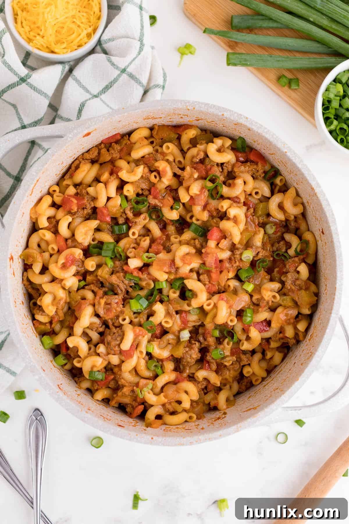A pot of beef taco pasta, rich with sauce and cheese.