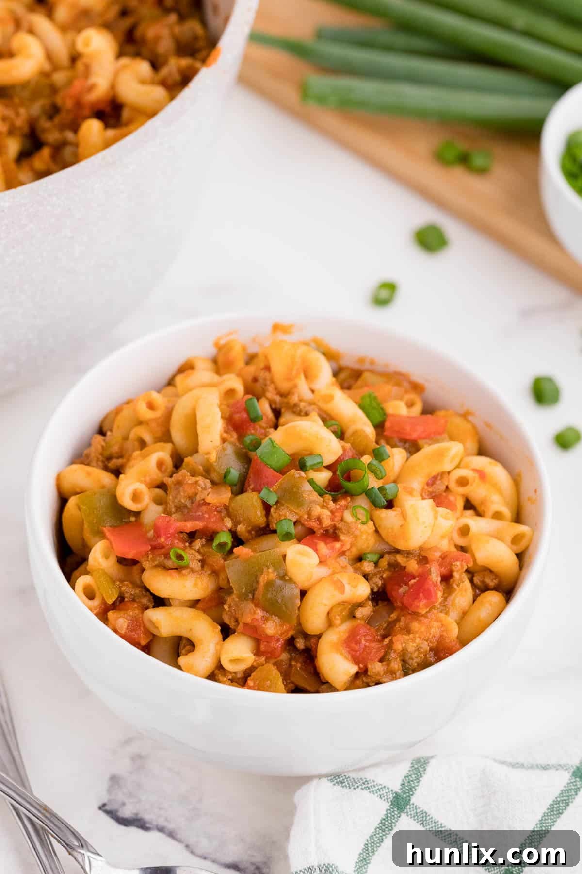 A white bowl of beef taco pasta, ready to be enjoyed.