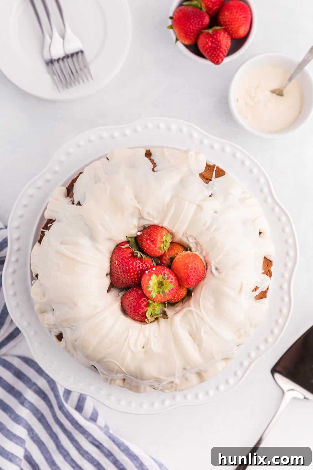 Vanilla Cream Cheese Cake on a white background with fresh strawberries, ready to be served.