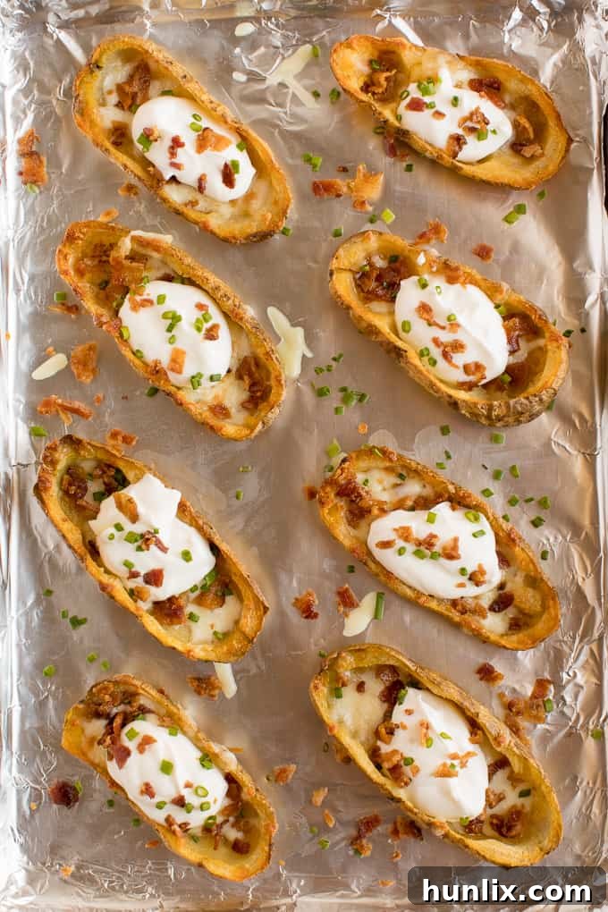 Cheesy Potato Skins - Topped with sour cream, tasty bacon and fresh green onions, this appetizer recipe is a crowd-pleasing classic.
