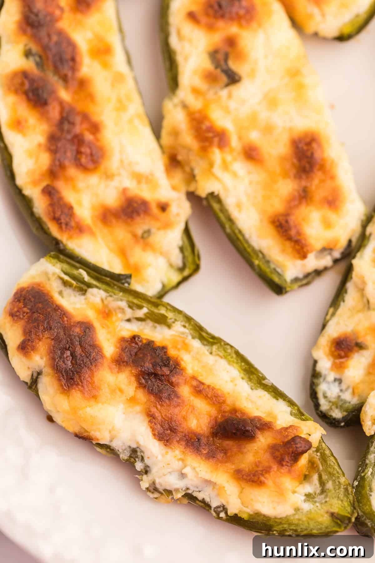 A plate of golden-brown cream cheese stuffed jalapenos, beautifully arranged and ready to be enjoyed.