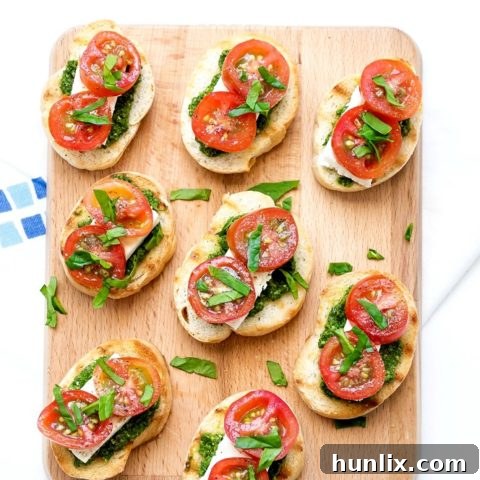 Pesto Cream Cheese and Tomato Bruschetta - A super easy, flavorful, and delicious appetizer recipe with bread, pesto, cream cheese, and tomatoes.