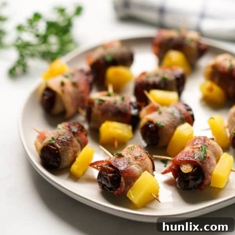 Bacon Wrapped Dates with Pineapple - A fun and easy party appetizer. Warm, gooey dates wrapped in crispy bacon and topped with juicy pineapple, always a crowd pleaser!
