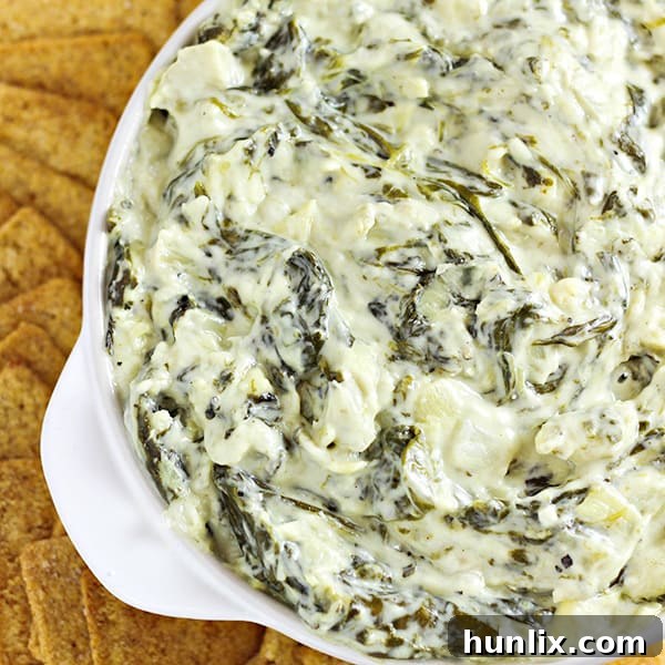 Slow Cooker Spinach and Artichoke Dip - A delicious, easy, and cheesy dip made in your crock pot with fresh spinach, artichoke hearts, and multiple cheeses.
