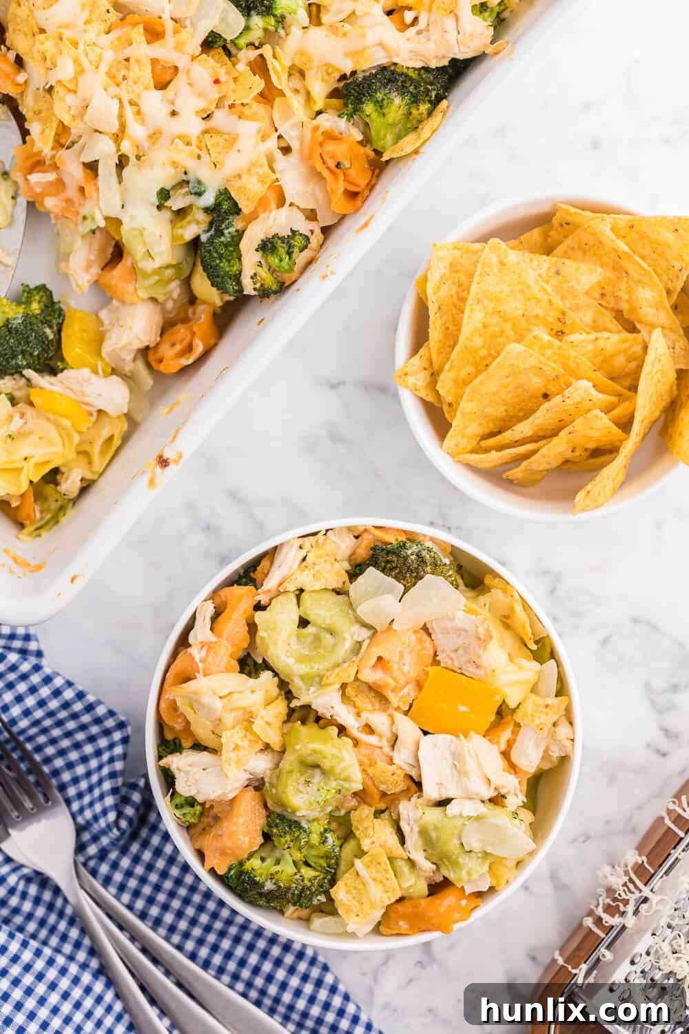 Overhead view of a baked Santa Fe Chicken Tortellini Casserole, bubbling with cheese and golden brown tortilla chips.