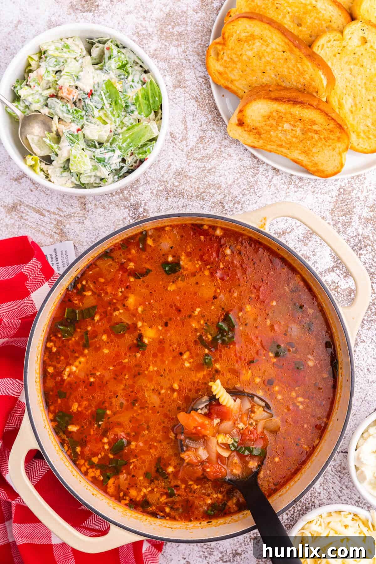 Lasagna soup in a dutch oven with a ladle.