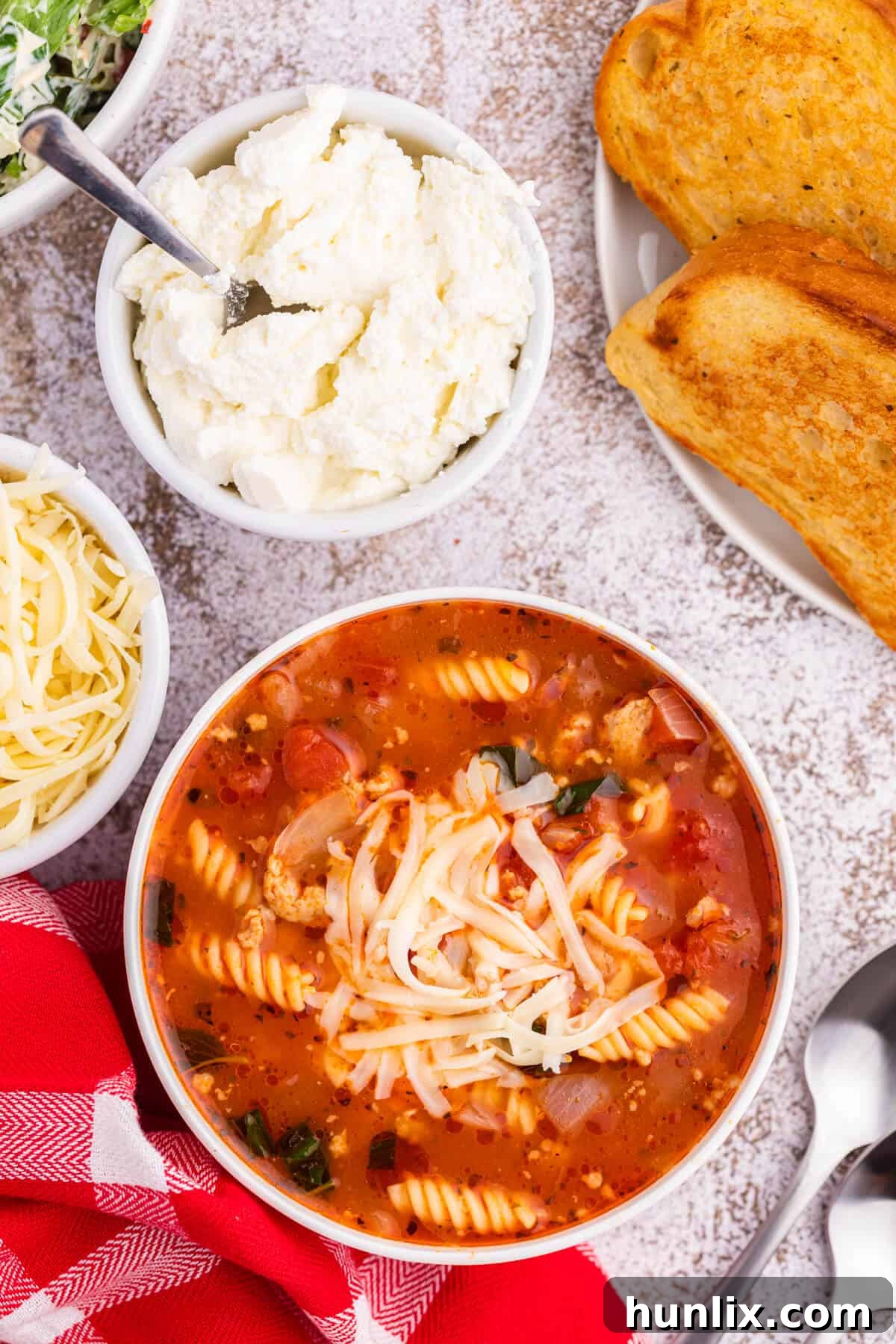 A bowl of the soup surrounded by ingredients.