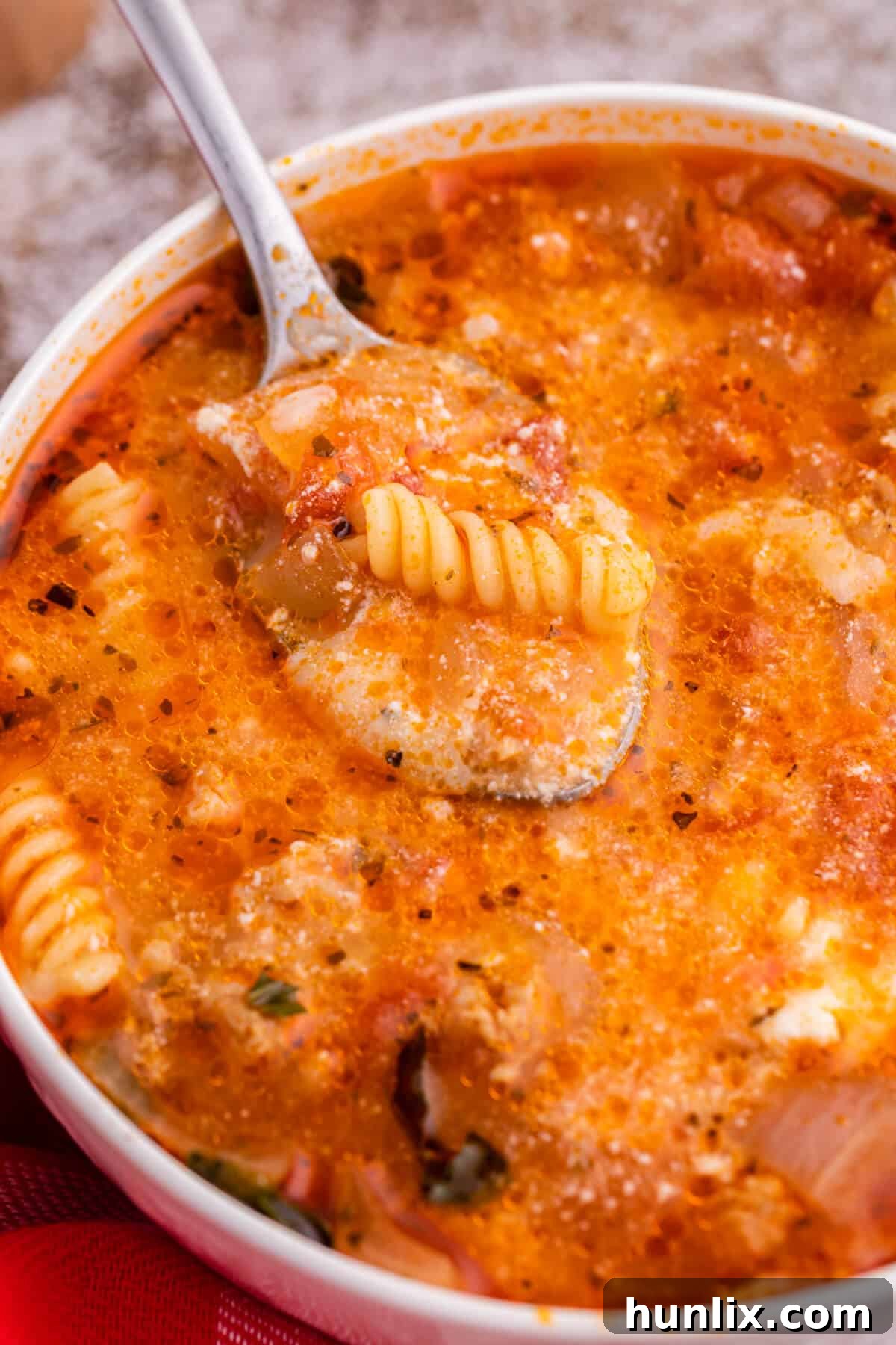 The soup in a white bowl with a spoon.