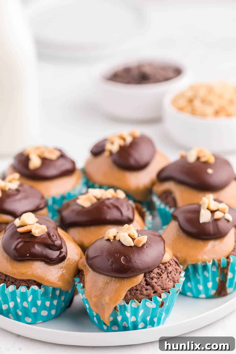 Peanut Butter Brownie Bliss 3 Close-up shot of a peanut butter brownie cupcake on a white plate, highlighting its layers.