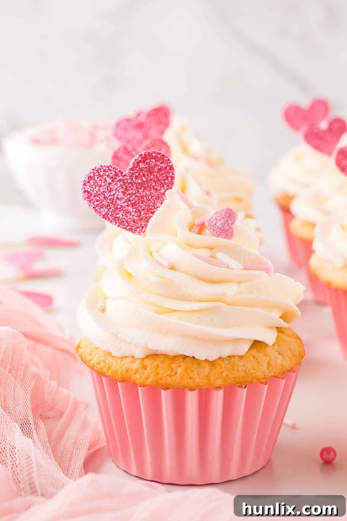 Beautifully decorated Valentine's Day cupcakes on a white surface, ready to be enjoyed.