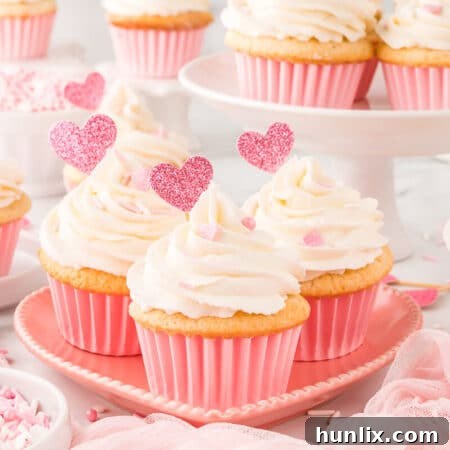 A frosted Valentine's Day cupcake on a heart plate, decorated for the holiday.