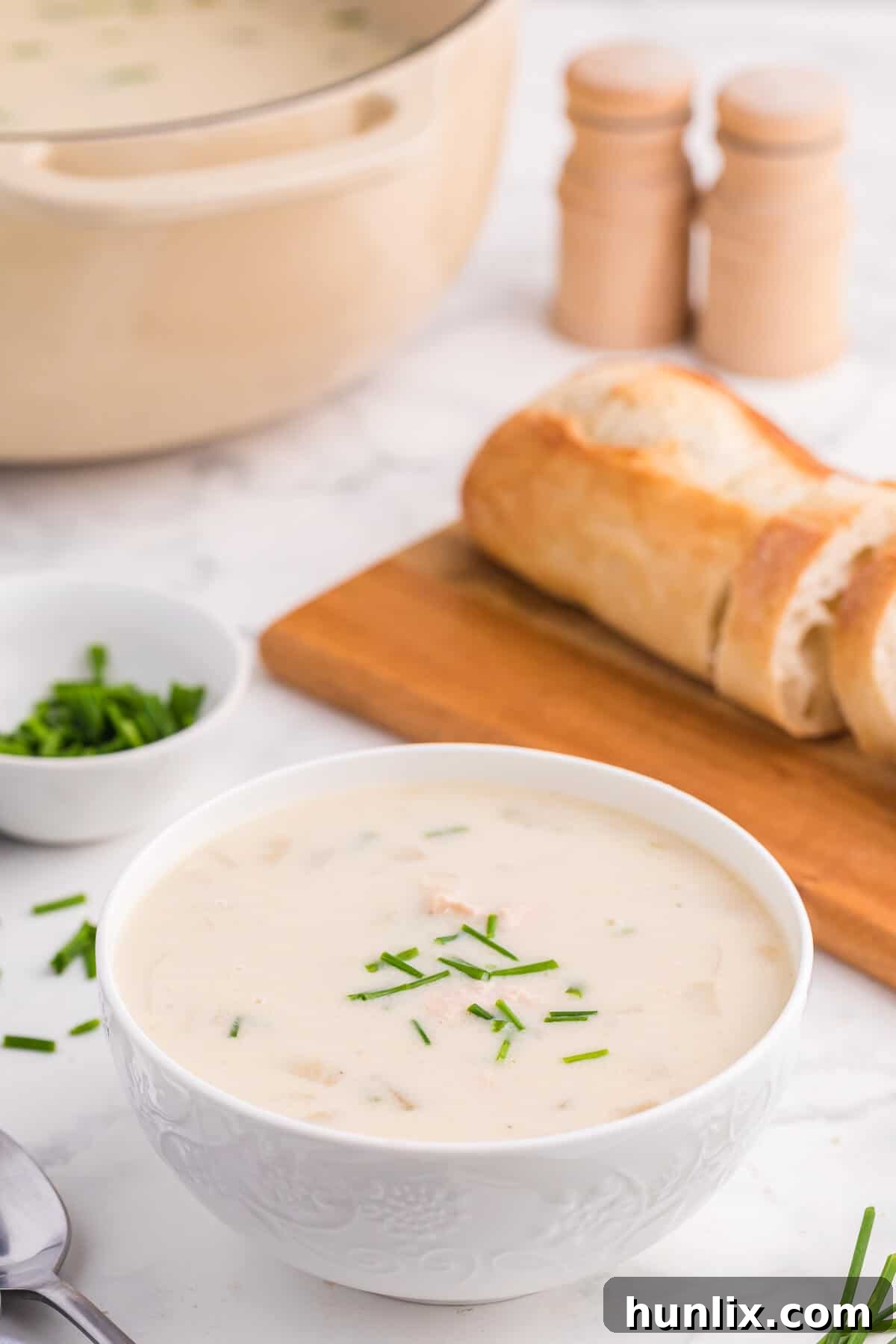 A white bowl of salmon chowder.