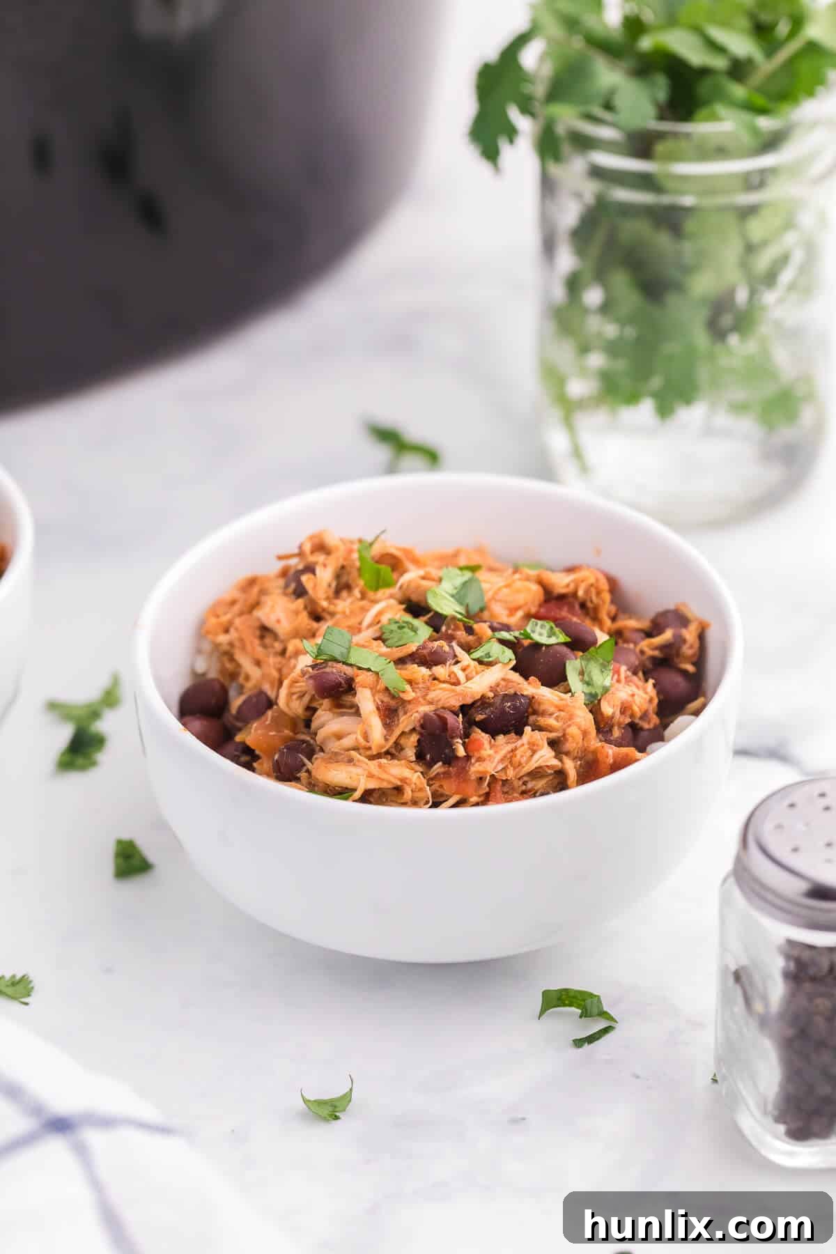 A close-up shot of a bowl of Slow Cooker Salsa Chicken, showing the shredded texture and rich sauce.