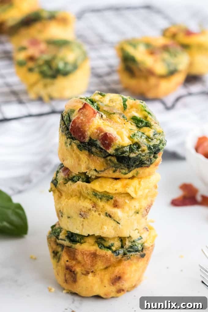 A neat stack of three perfectly cooked spinach and cheese egg muffins, ready for a quick and healthy breakfast or snack.