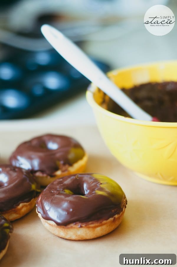 A stack of beautifully glazed Chocolate Cake Donuts, fresh from the oven, offering a delightful homemade treat.