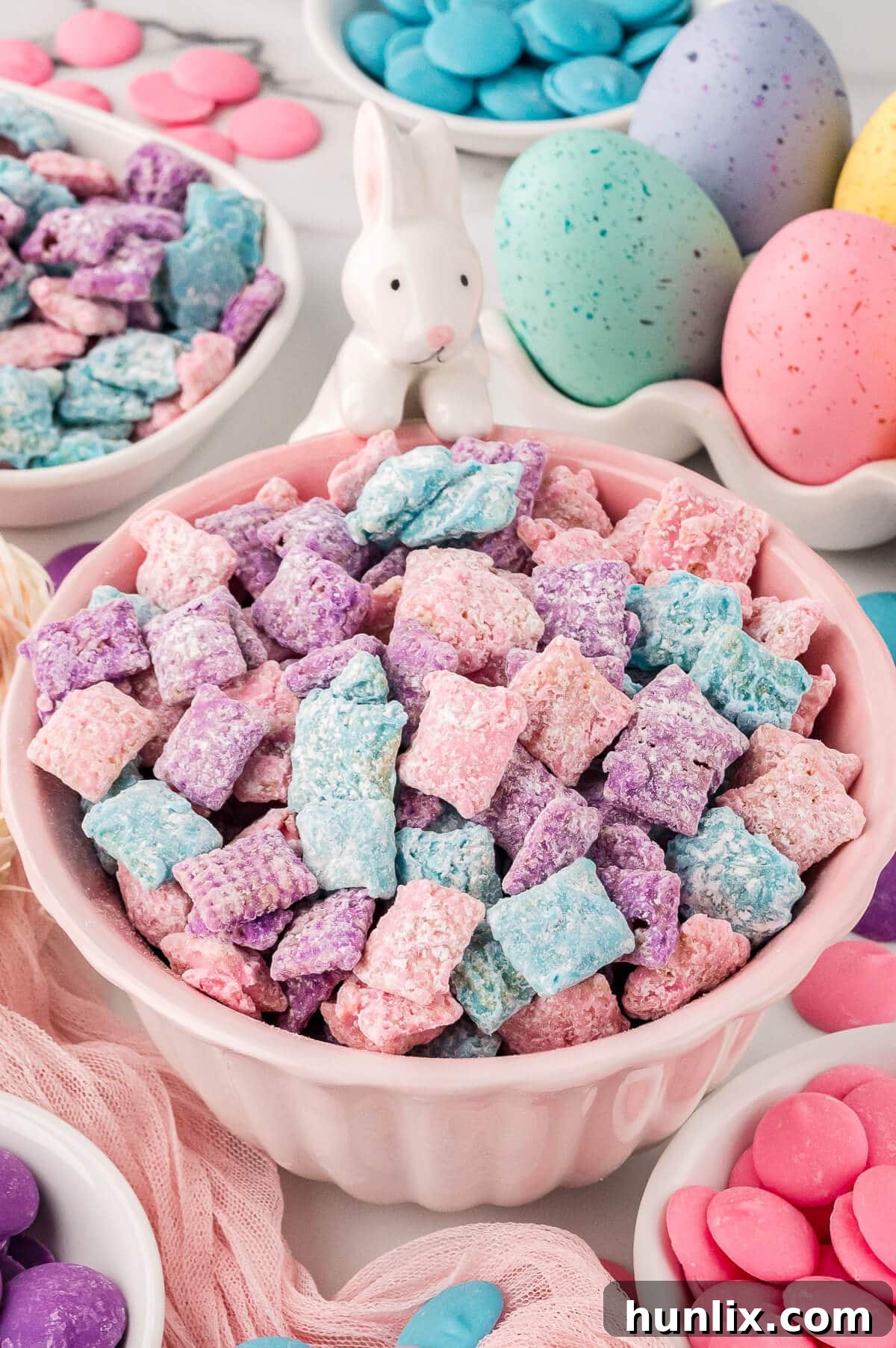 Easter Puppy Chow in a pink bowl, showcasing its vibrant pastel colors.